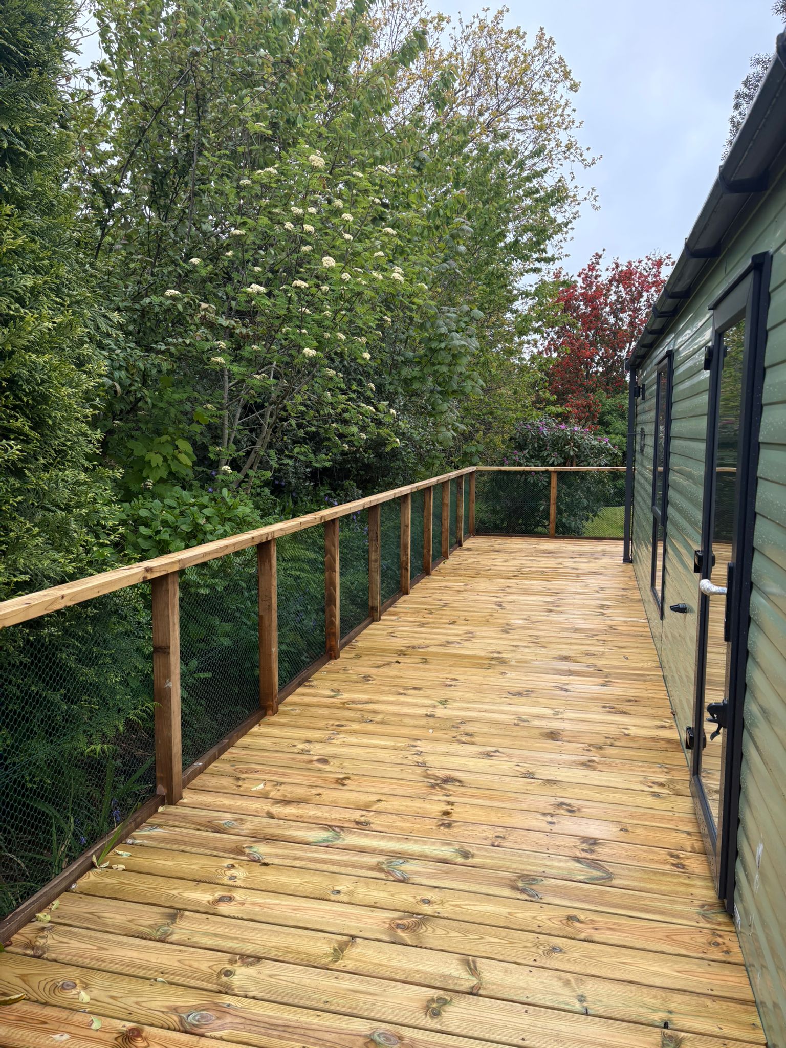 A long wide deck perfect for al fresco dining plus a sofa set and BBQ